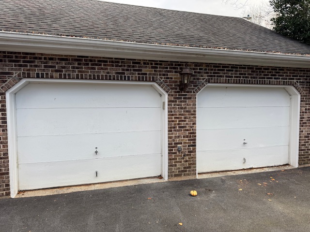worn white garage doors of a two car garage